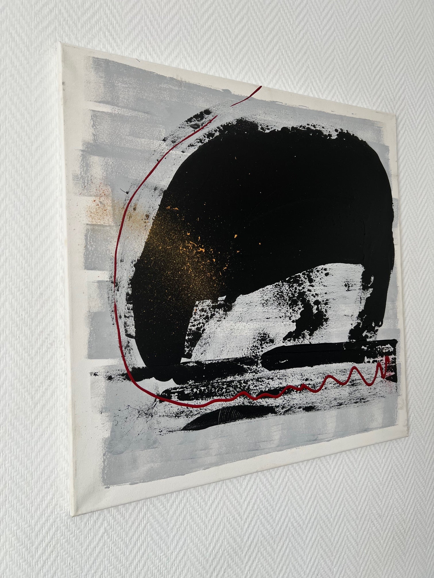 Peinture abstraite noir, blanc et rouge avec lignes graphiques et contrastes marqués pour un intérieur moderne et design.