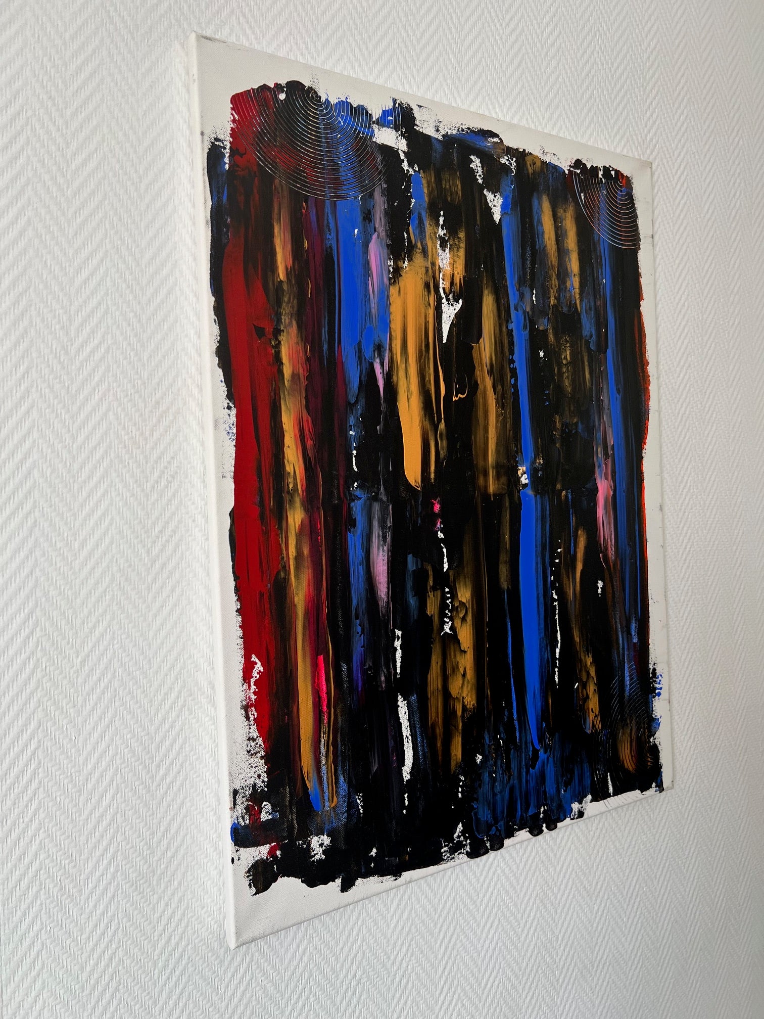 Peinture abstraite aux couleurs noir, bleu, or et rouge avec effets de matière pour un intérieur contemporain et élégant.