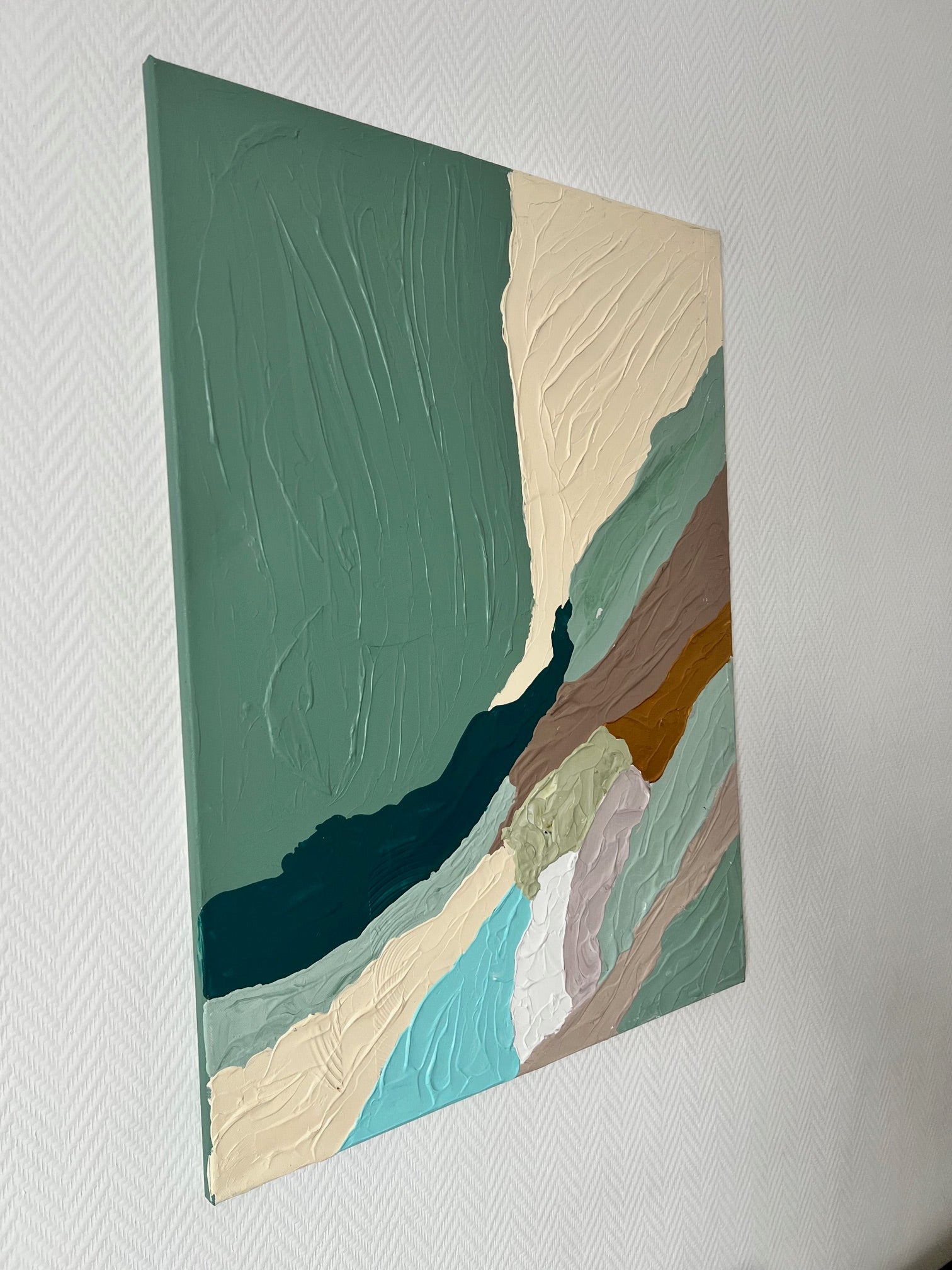 Peinture abstraite texturée aux couleurs vert sauge, beige, bleu pétrole et taupe, offrant un fort relief pour un intérieur moderne.